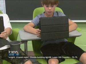 Image of child with an ipad from the KXAN Report on the KXAN site